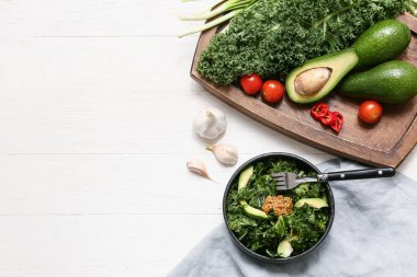 Lezzetli lahana salatası ve beyaz ahşap masada taze sebze kompozisyonu.