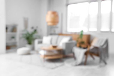 Kanepesi, koltuğu ve pencereye yakın şık kahve masası olan modern oturma odasının bulanık görüntüsü