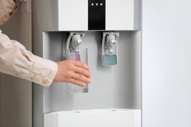 Kadın elleri arka planda serinletici sulardan su dolduruyor