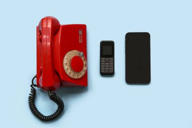 Düğmeli telefon ve mavi arka planda akıllı telefon. Evrim kavramı