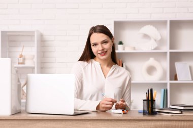 Genç diyabetik kadın ofisinde tükenmez kalemle kan örneği alıyor.