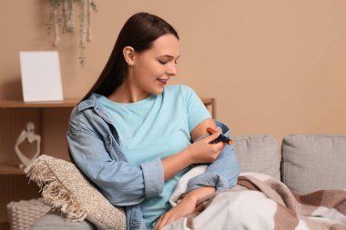 Şeker hastası kadın evde kendine insülin iğnesi yapıyor.