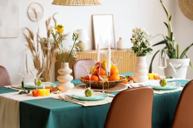 Oturma odasında turunçgiller ve yanan mumlarla dolu güzel bir masa.