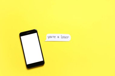 Sarı arkaplan üzerinde boş cep telefonu olan bir konuşma balonu