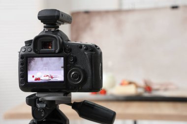 Çilekli lezzetli cheesecake ve sütle stüdyoda profesyonel fotoğraf makinesi sergileniyor.