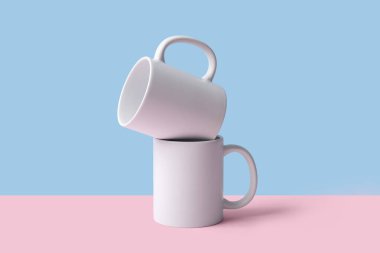 Pembe masada mavi arka planda seramik bardaklar