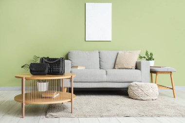 Oturma odasının içindeki masada şık çantalar var.