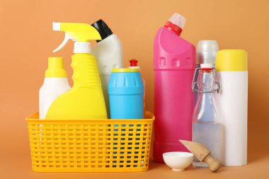 Sirkeli temizlik malzemeleri ve turuncu arka planda kabartma tozu.