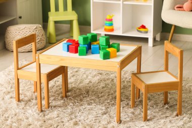 Çocuk odasındaki masada plastik küpler.