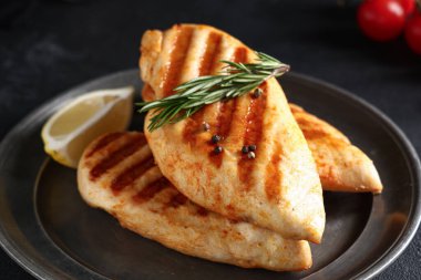 Lezzetli ızgara tavuk göğsü, biberiye, biberiye ve limon dilimi, yakın plan.