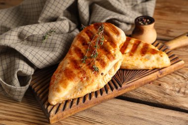 Lezzetli ızgara tavuk göğsü, kekik ve ahşap arka planda biber.