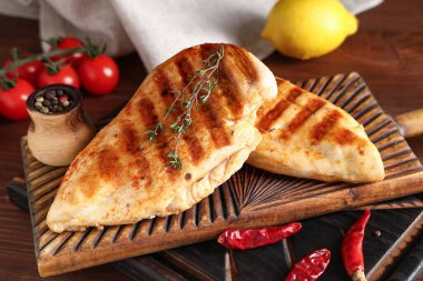 Lezzetli ızgara tavuk göğsü, kekik, kurutulmuş kırmızı biber ve ahşap zemin üzerinde biber.