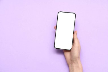 Mor arka planda cep telefonu olan bir kadın el.