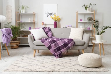 Rahat kanepesi ve güzel mimoza çiçekleri olan modern oturma odasının şık bir iç mekanı.