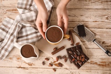 Bir fincan erimiş çikolatalı kadın elleri. Üst görünüm