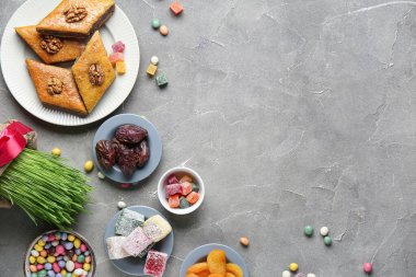 Yeşil buğday çimi ve gri grunge arka planda geleneksel tatlılar. Nowruz Bayram kutlaması