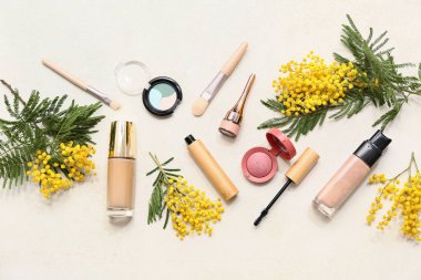 Beyaz arka planda dekoratif kozmetik ve mimoza çiçekleri