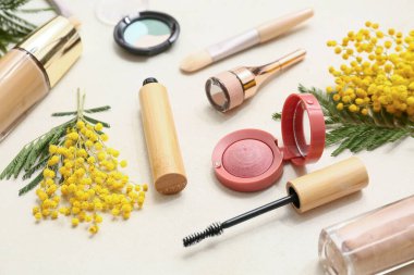 Dekoratif kozmetik ürünleri ve beyaz arka planda mimoza çiçekleri, yakın plan