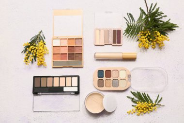 Beyaz arka planda dekoratif kozmetik ve mimoza çiçekleri