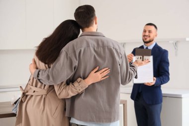 Mutfakta kira sözleşmesi olan genç bir çift ve emlakçı.