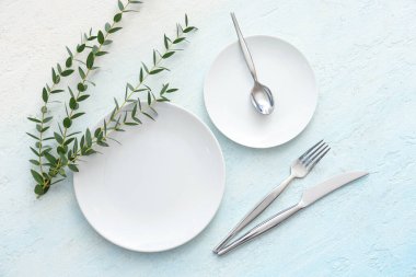 Mavi grunge arka planında okaliptüs dalları olan güzel bir masa. Üst görünüm