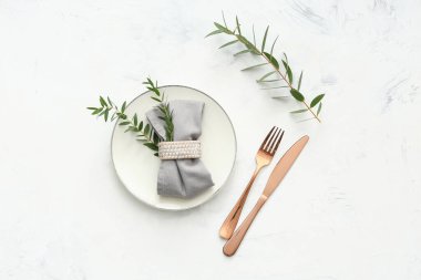 Beyaz grunge arka planında okaliptüs dalları olan güzel bir masa. Üst görünüm