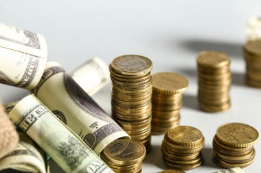 Gri zemin üzerinde dolar olan altın sikkeler