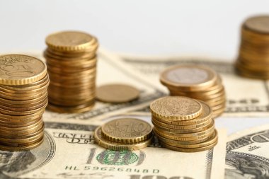 Gri zemin üzerinde dolar olan altın sikkeler