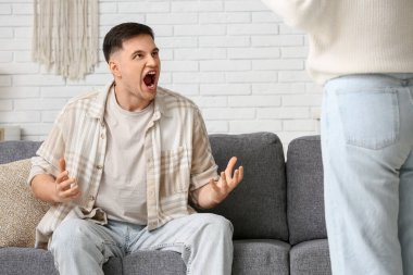 Kızgın genç çift evde kavga ediyor.