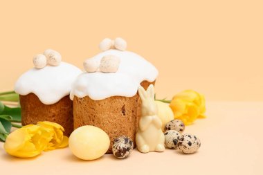 Yumurtalı Paskalya pastaları, oyuncak tavşan ve sarı arka planda güzel lale çiçekleri.