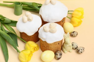 Yumurtalı Paskalya pastaları, oyuncak tavşan ve sarı arka planda güzel lale çiçekleri.