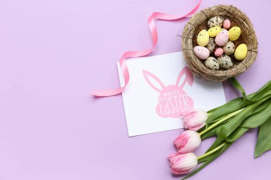 Paskalya yumurtalı yuva, tebrik kartı ve leylak arka planda güzel lale çiçekleri.