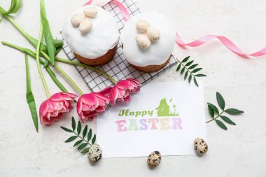 Yumurtalı Paskalya pastası, tebrik kartı ve beyaz arka planda güzel lale çiçekleri.