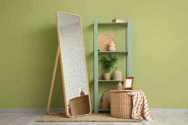 Zemin aynası ve yeşil raf ünitesi olan şık bir oda.