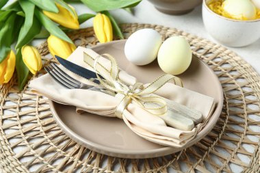 Paskalya kutlaması için şık bir masa ayarı. Beyaz grunge arka planda lale çiçekleri, yakın plan.