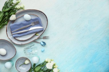 Mavi grunge arka planında östoma çiçekleri olan Paskalya kutlaması için şık masa düzenleme