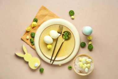 Paskalya kutlaması için bej arkaplanda çiçekler olan şık masa ayarları