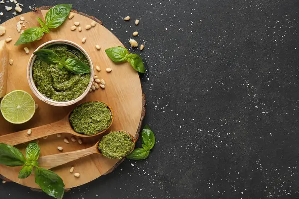 Bir kase dolusu lezzetli pesto sosu ve siyah grunge arkaplan içeriği.
