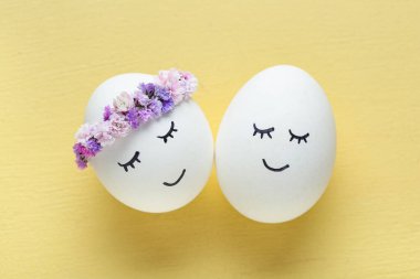 Sarı arka planda çizilmiş şirin Paskalya yumurtaları, yakın plan.