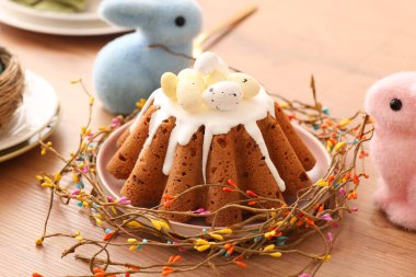 Tahta masadaki tatlı Paskalya ekmeği ve oyuncak tavşanlar