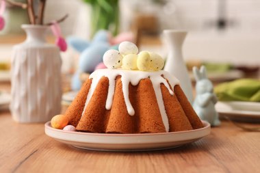 Mutfaktaki ahşap masada yumurtalı bir tabak tatlı Paskalya ekmeği.