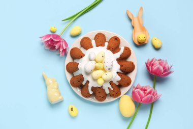 Yumurtalı Paskalya ekmeği tabağı ve mavi arka planda güzel lale çiçekleri.