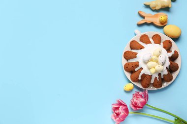 Yumurtalı Paskalya ekmeği tabağı ve mavi arka planda güzel lale çiçekleri.