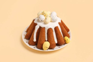 Sarı arka planda yumurtaları olan bir tabak tatlı Paskalya ekmeği.