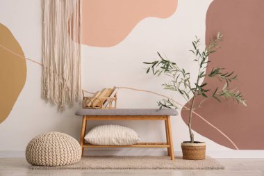 Yastıklı, yumuşak gri bir bank ve odada puf.