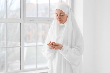 Genç Müslüman kadın evde dua ediyor. Ramazan kutlaması