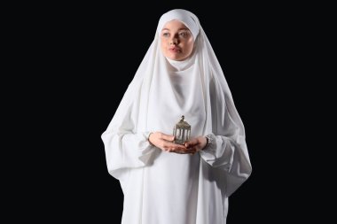 Siyah arka planda hayranları olan genç Müslüman bir kadın. Ramazan kutlaması
