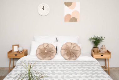 Yatak odasının içi komodinli, büyük yataklı ve yastıklı.