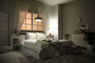 Yatak odasının içi komodinli, çekmeceli, büyük yataklı ve akşamları parlayan lambalı.