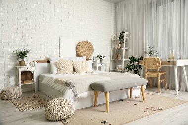 Yatak odasının içi komodinli, yatak masalı, masa ve büyük yataklı.